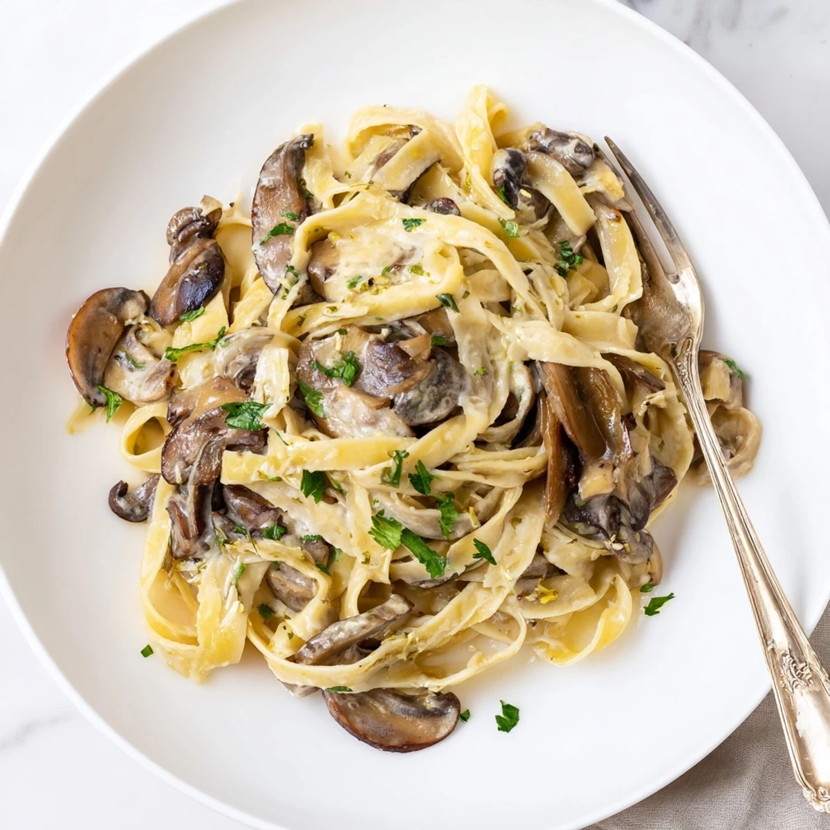 Delicious creamy one-pot mushroom pasta garnished with fresh parsley and melted cheese.  