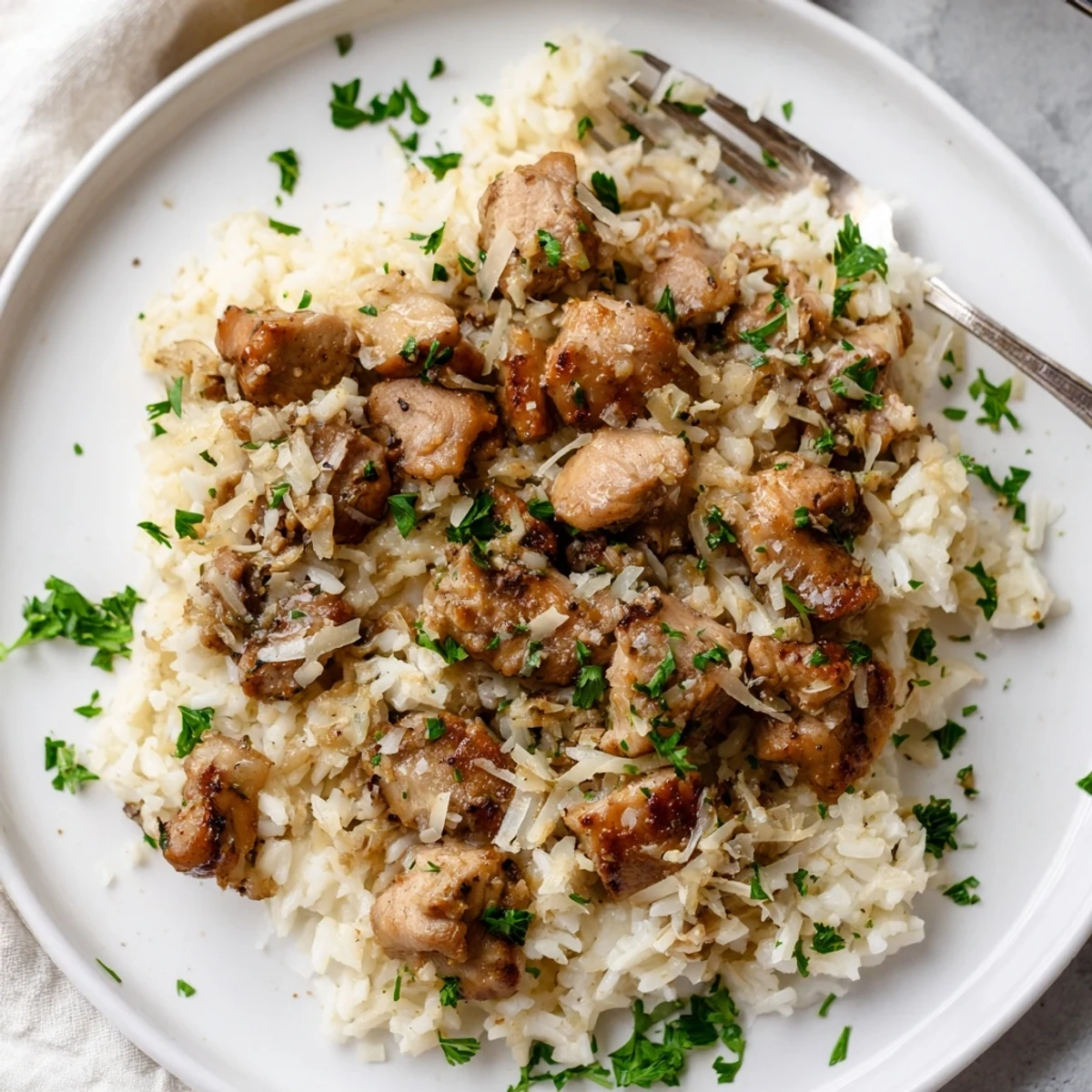 Tender chicken thighs simmer with aromatic garlic and fluffy rice for easy comfort food.  