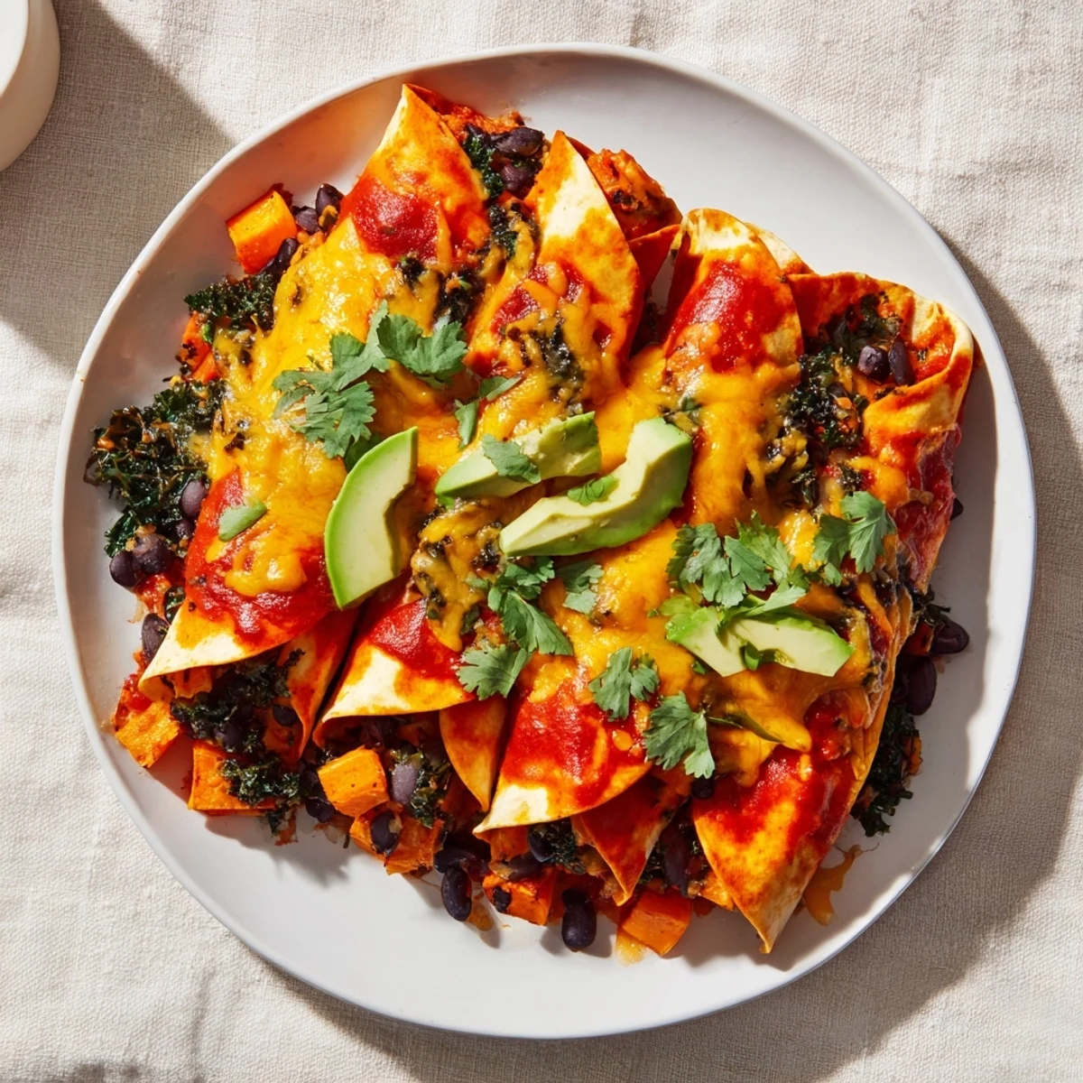 Golden-brown One-Pan Sweet Potato, Black Bean & Kale Enchiladas, topped with bubbly, melted cheese.