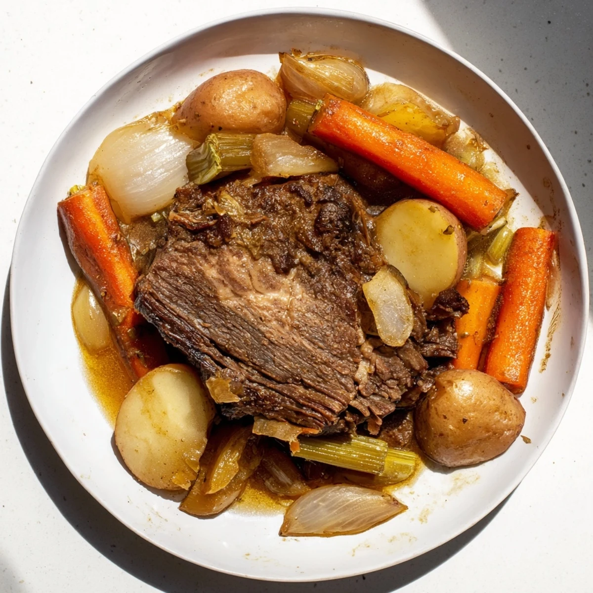 A close-up view of a steaming Pickle Brine Pot Roast, showcasing its juicy, shredded beef with hearty veggies.