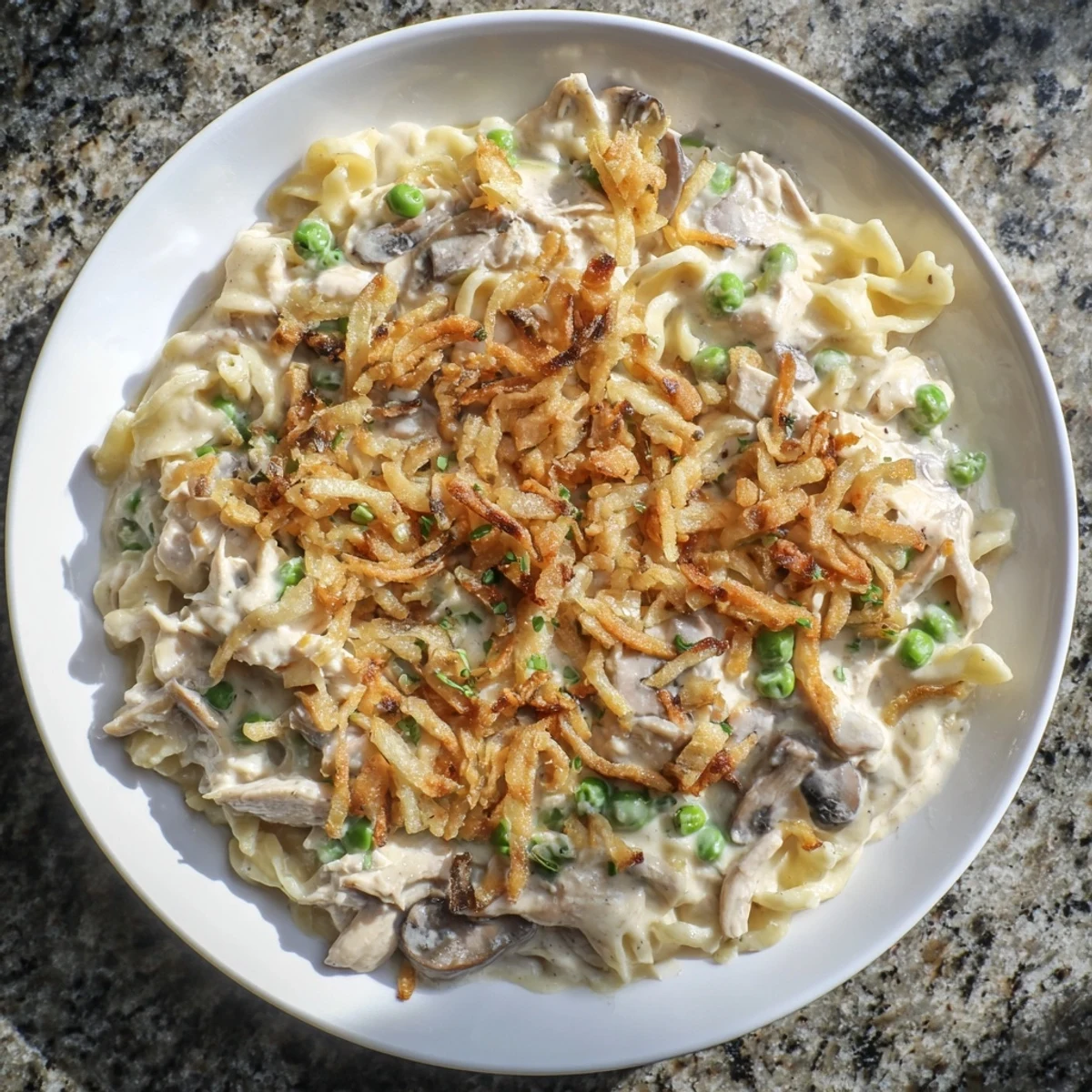 A close-up of creamy, flavorful Homemade Tuna Noodle Casserole with a crispy onion topping.