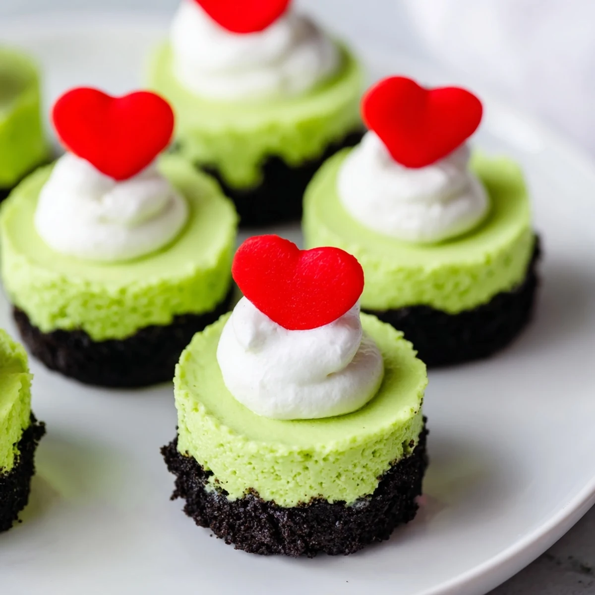 A close-up of festive Grinch Mini Cheesecakes: creamy, green, and perfect for Christmas dessert.