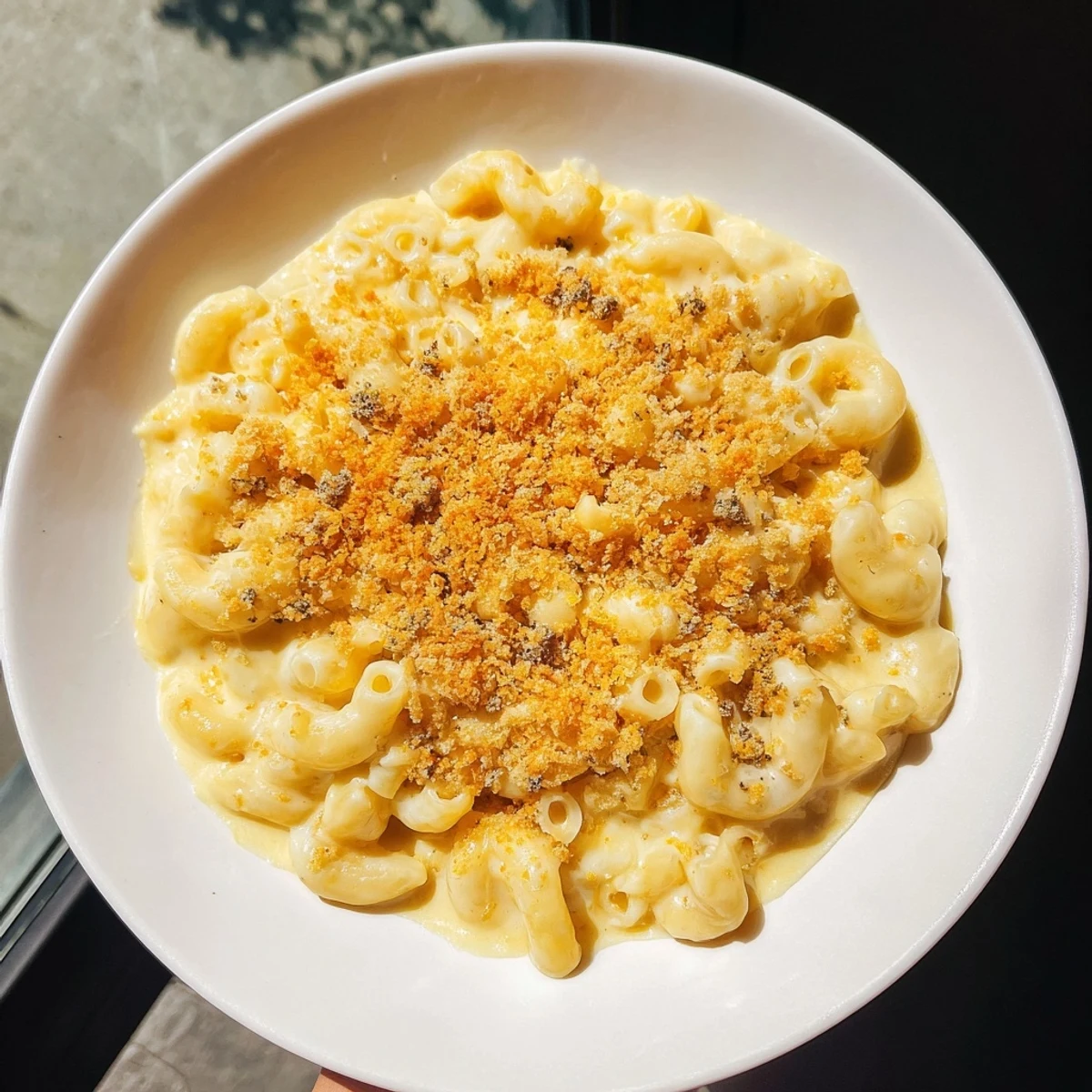 Golden, bubbly Tinis Recession Mac and Cheese, a budget-friendly comfort food classic, ready to serve.