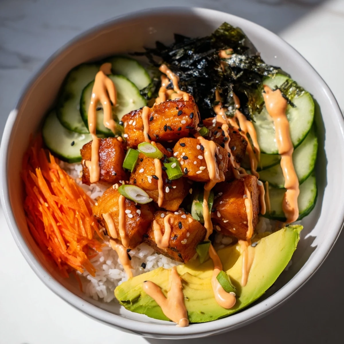 Freshly prepared salmon bites bowl, featuring diced salmon with vibrant toppings and creamy spicy sauce.