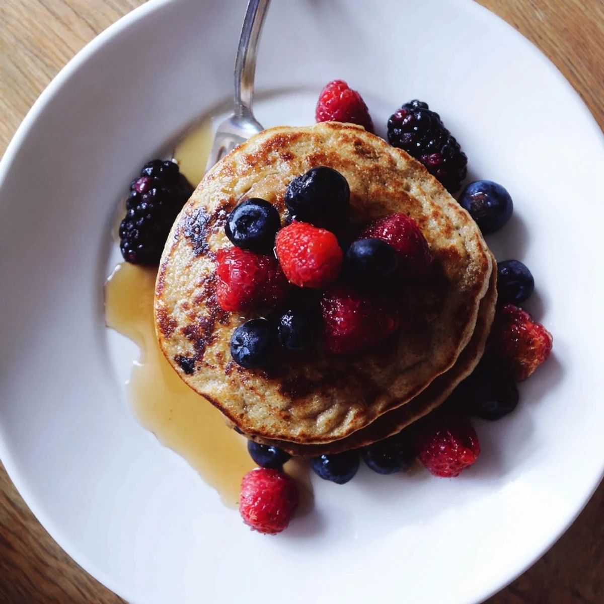 Thin, delicate banana pancakes glistening with natural sweetness, ready to serve with a dollop of Greek yogurt.