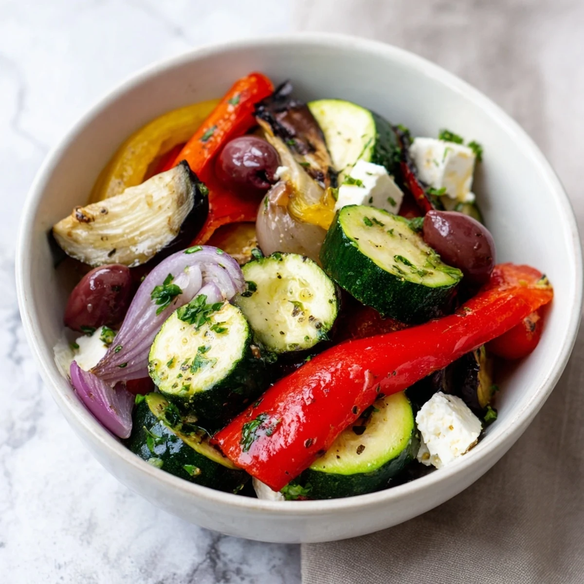 Freshly roasted red and yellow bell peppers, red onion, zucchini, and eggplant mingle with crisp cucumber and Kalamata olives in this warm Roasted Greek Salad.  