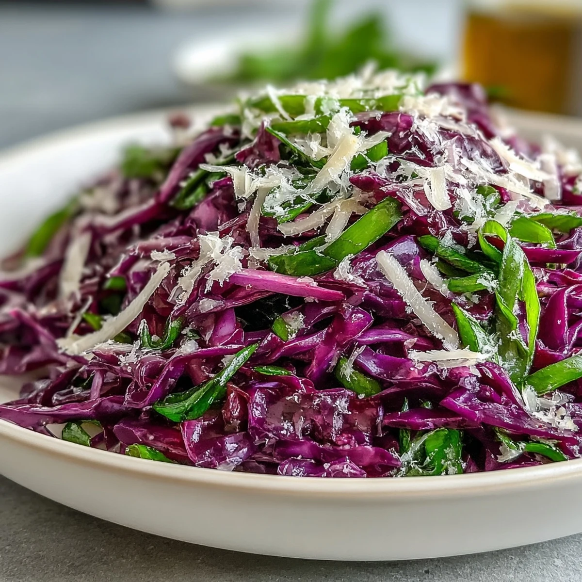A crisp bowl of Red Cabbage Coleslaw With Apple and Parmesan next to grilled chicken for serving.