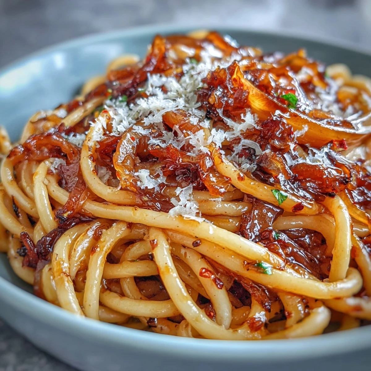 Freshly cooked spaghetti tossed with golden, sweet caramelized onions, drizzled with a homemade spicy chili oil and sprinkled with Parmesan.