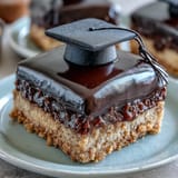 Easy Graduation Cookies with Fondant Mortarboard displayed on a festive platter, each topped with a black fondant cap and yellow tassel for a celebratory dessert.