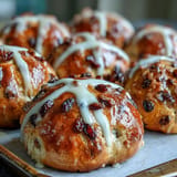 Plump, spiced hot cross buns fresh from the oven, brushed with apricot glaze and ready to serve with butter or jam.  
