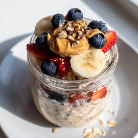 Creamy overnight oats jars layered with fruit and peanut butter, a delightful breakfast idea.