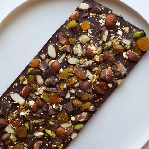 A close-up of delicious Simplified Dubai Chocolate Bark, scattered with nuts and dried fruits.