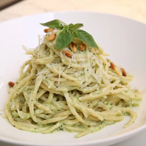 A steaming bowl of 15-Minute Creamy Pesto Risoni, garnished with fresh basil and pine nuts.