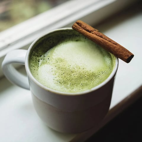 Warm Maple Cinnamon Gingerbread Matcha Oat Latte with a dusting of cinnamon, inviting to sip.