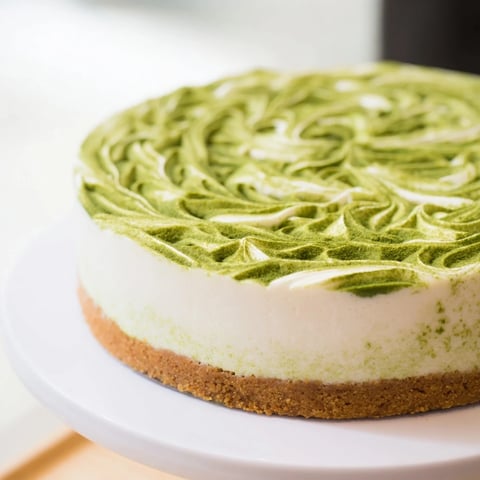 Creamy Matcha Swirl Snowdrift Cheesecake Cups swirled with vibrant green matcha, atop a golden crust and ready to chill.