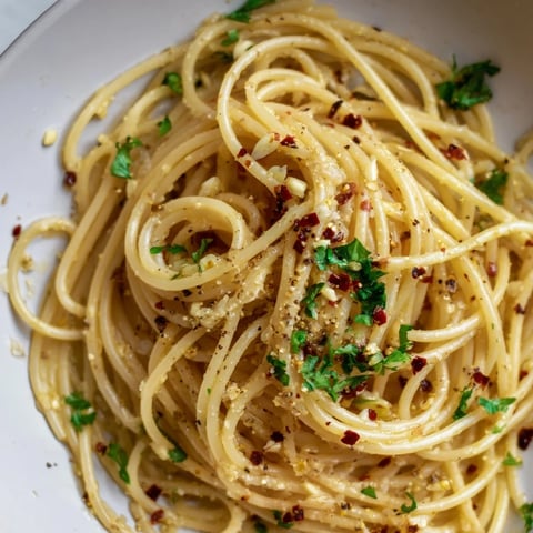 Steaming bowl of Aglio e Olio Express Pasta with bright green parsley, a quick and delicious weeknight dinner.