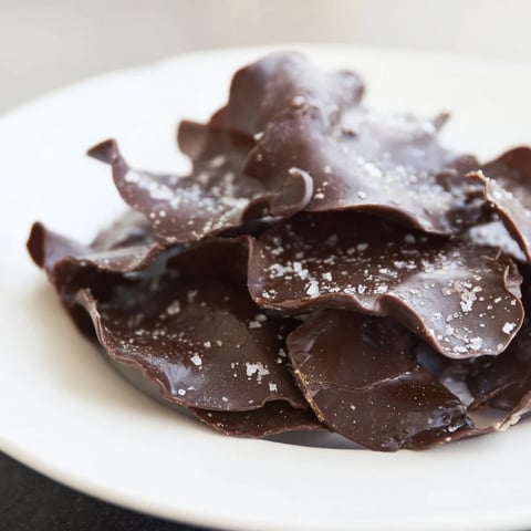 Melted chocolate drizzled over potato chips, a sweet and salty Chocolate Potato Chip Bark.