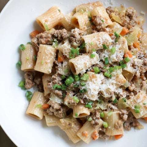 Steaming bowl of Chaos Cooking Kimchi Ragu Pasta, with ribbons of pasta and a rich, spicy sauce.