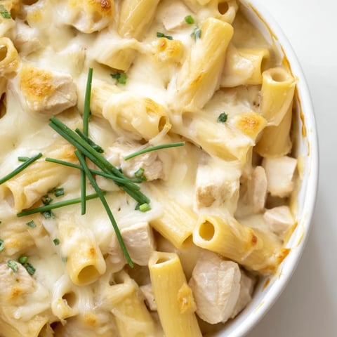 Golden, bubbly mozzarella tops a creamy Chicken Ranch Pasta Bake, featuring tender chicken pieces and penne pasta nestled in a rich, herb-flecked sauce.