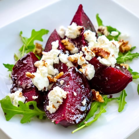Tender roasted beet wedges, creamy goat cheese crumbles, and toasted walnuts tossed with fresh arugula for a vibrant salad.  