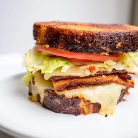 Golden-brown grilled sourdough holds melty vegan cheese, smoky tempeh bacon, crisp lettuce, and ripe tomato slices in this Vegan Bacon BLT Grilled Cheese.