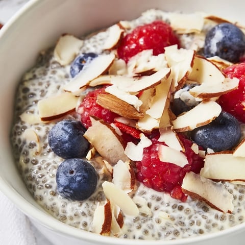 Creamy Poppy Seed Chia Pudding layered in a glass jar, topped with fresh blueberries and toasted almonds for a nourishing breakfast.