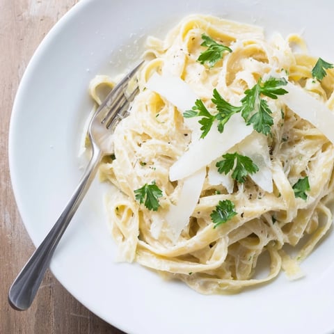 Creamy fettuccine coated in a velvety cauliflower Alfredo sauce, garnished with fresh parsley and grated Parmesan.  