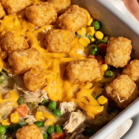 Golden-brown tater tots topping a bubbly, savory Tater Tot Chicken Pot Pie, ready to serve.