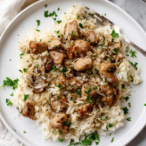 Tender chicken thighs simmer with aromatic garlic and fluffy rice for easy comfort food.  