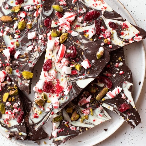 Delicious Holiday Bark, showcasing a close-up of colorful peppermint, coconut, and nut-studded chocolate pieces.