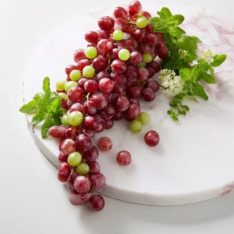 Fresh, colorful grapes cascading off a board, a simple and elegant fruit appetizer ready to enjoy.