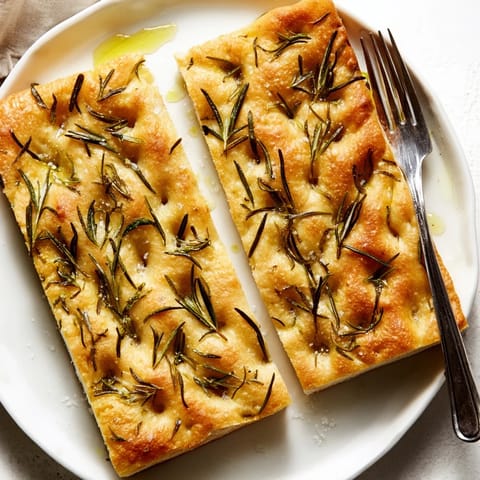 Warm, pillowy focaccia bread, freshly baked and topped with rosemary, ready to serve for holidays.