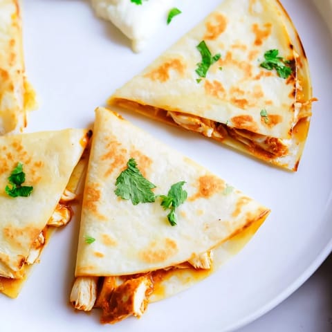 Melting cheese overflowing from a beautifully browned Butter Chicken Quesadilla, a delicious visual treat.