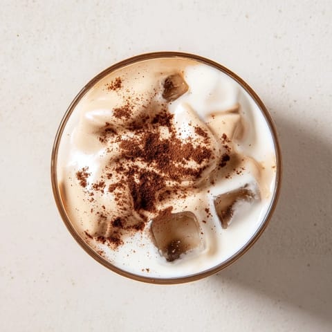 Two glasses of whipped Dalgona coffee layered over ice and milk for a creamy café-style treat.  