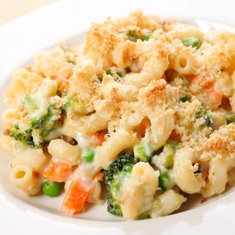A spoonful of Garden Veg Mac and Cheese reveals tender vegetables and a velvety three-cheese sauce in a cozy serving.