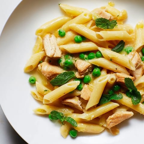 Spoonfuls of the Pea & Mint Chicken Pasta reveal glossy penne with flecks of fresh herbs and shaved Parmesan.  