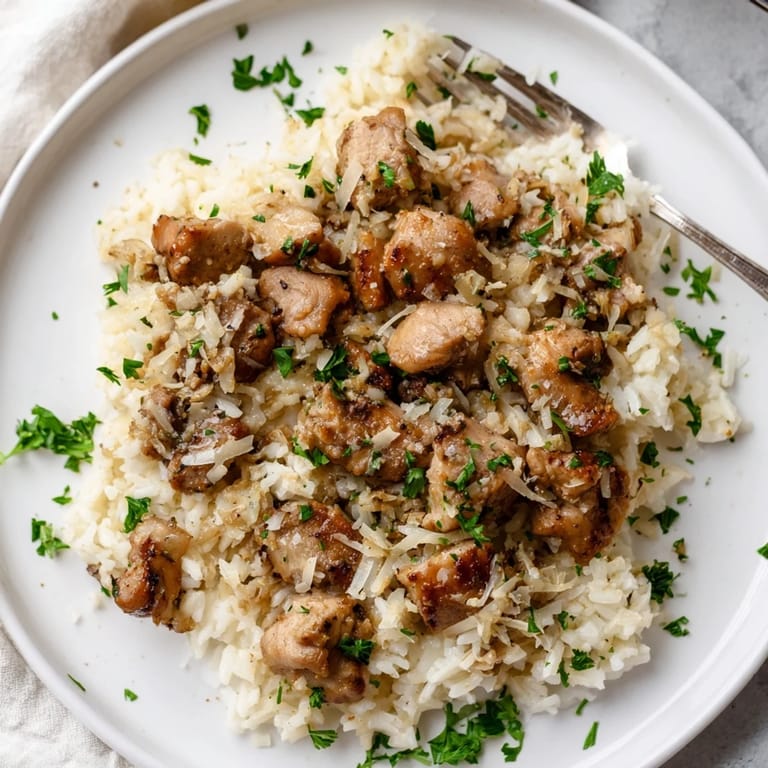 Tender chicken thighs simmer with aromatic garlic and fluffy rice for easy comfort food.  