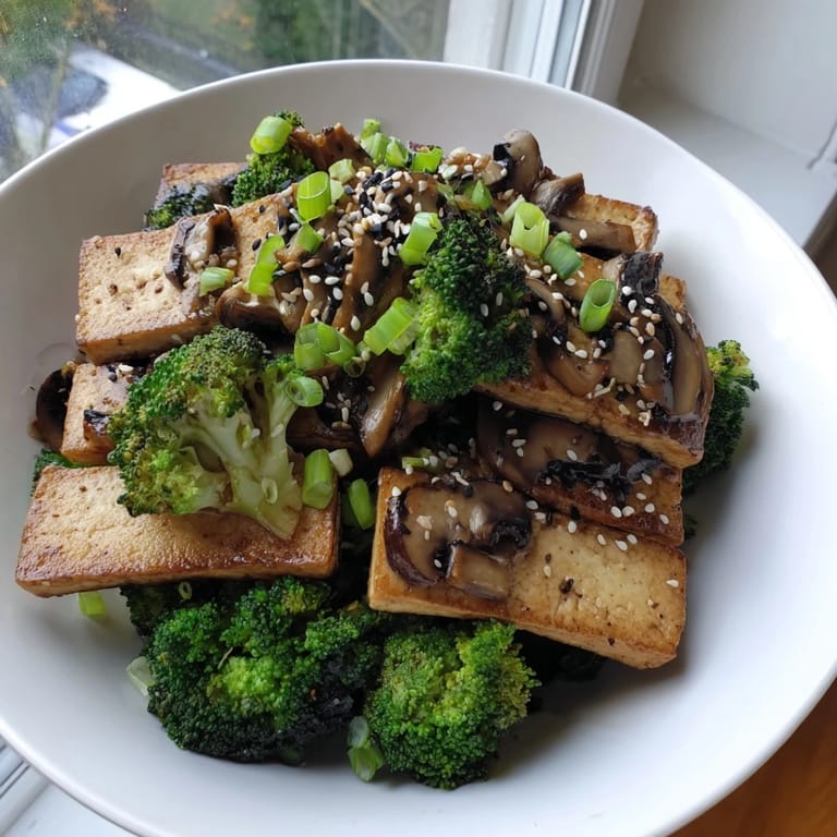 A close-up view of perfectly seared Sautéed Tofu Steak, complemented by tender broccoli and a rich sauce.