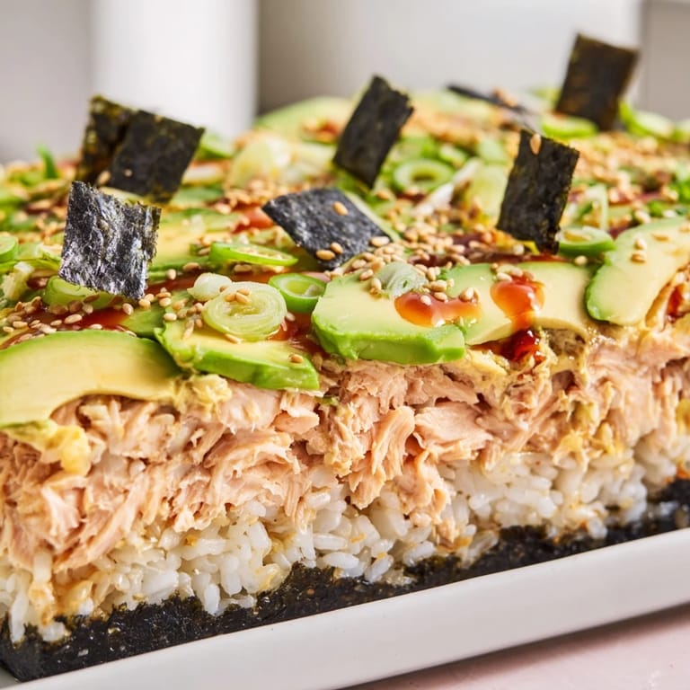 A delicious, oven-baked sushi bake casserole topped with sesame seeds and nori squares, ready to serve.