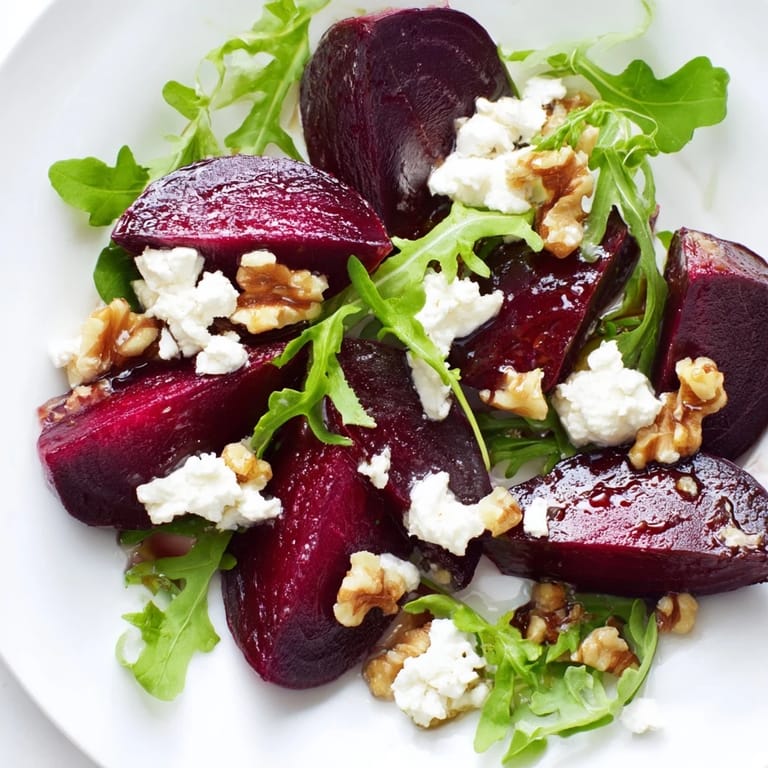 Roasted beet goat cheese salad served on a white plate, featuring bright red beets and crumbles of tangy goat cheese.