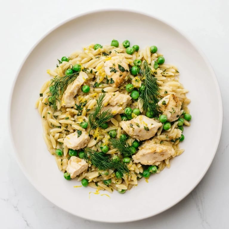 Tender chicken thighs and al dente orzo pasta tossed with peas and fresh herbs in a lemony sauce.
