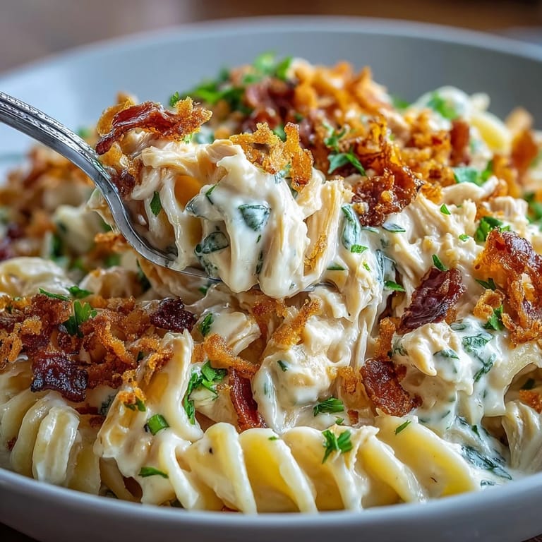 Fork twirling through creamy jalapeño popper chicken pasta with shredded chicken, bacon, and spicy cheese sauce.